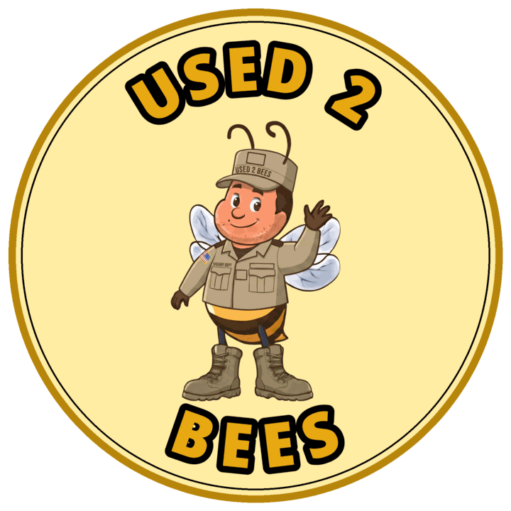 Female Used 2 Bees Navy officer mascot in double-breasted dark blue dress coat with gold buttons, gold sleeve stripes on each cuff, white shirt and black neck tab, hair in a bun, white-top combination cap with officer device and USED 2 BEES band and black dress shoes